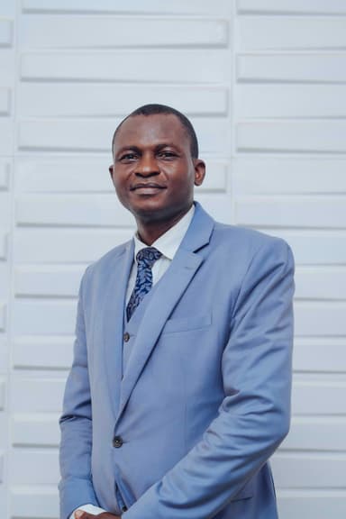 A professional headshot of Olusanmi Ajao, Senior Pastor at RCCG Ceaseless Joy.